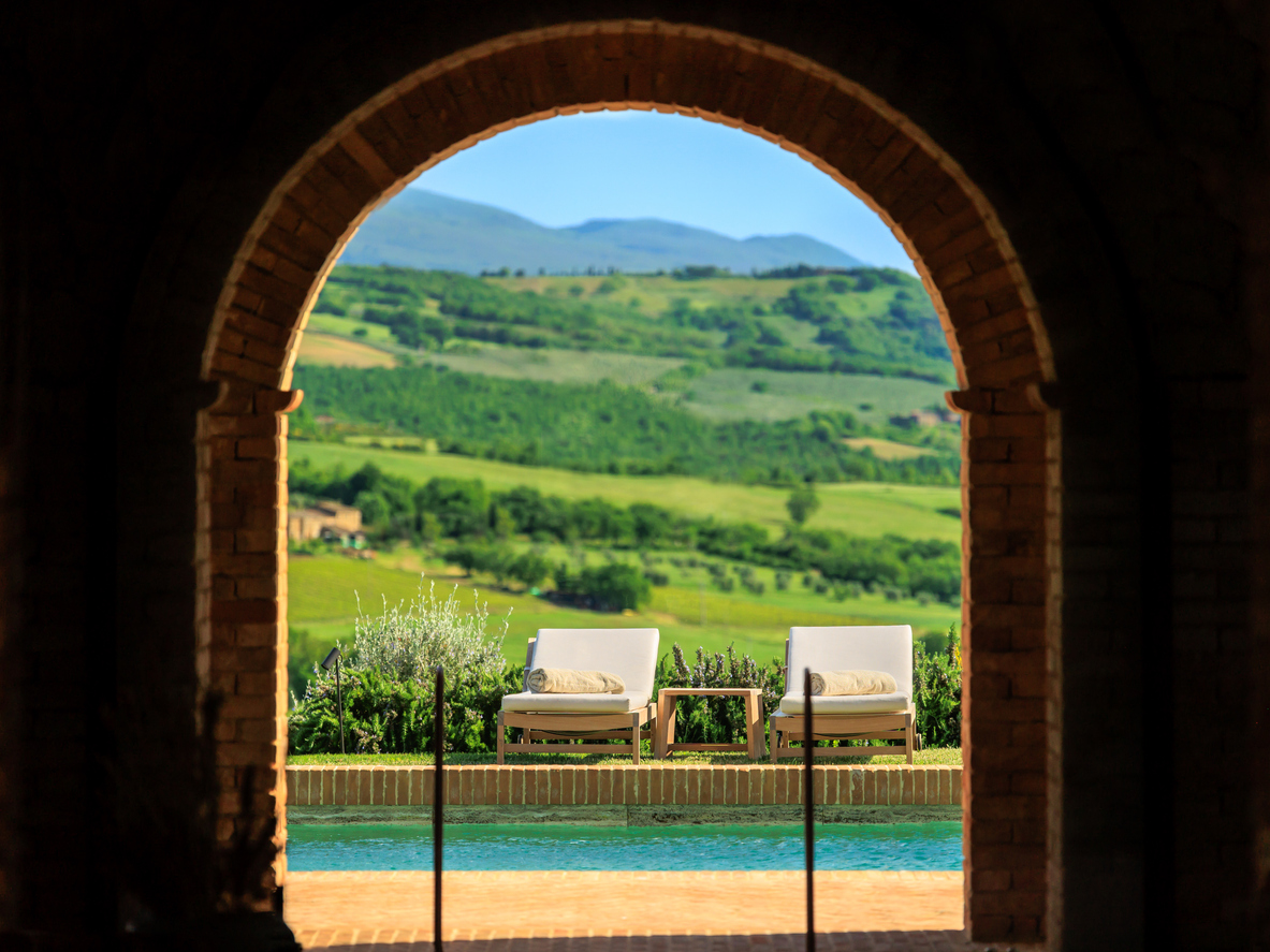 Vista panoramica su una villa con piscina immersa nel verde, perfetta per soggiorni esclusivi su richiesta in Italia